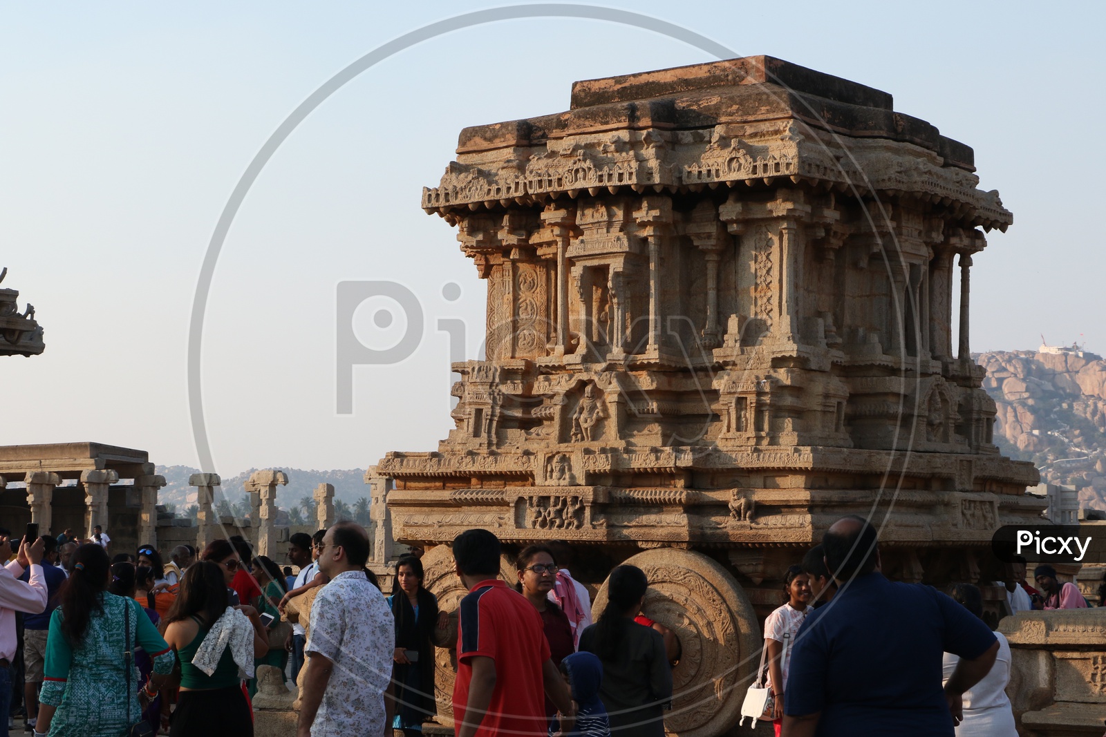 Tourists / Visitors At an  Old Ancient Dravidian Vitthala Temple /  Stone Chariot in Hampi , Karnataka