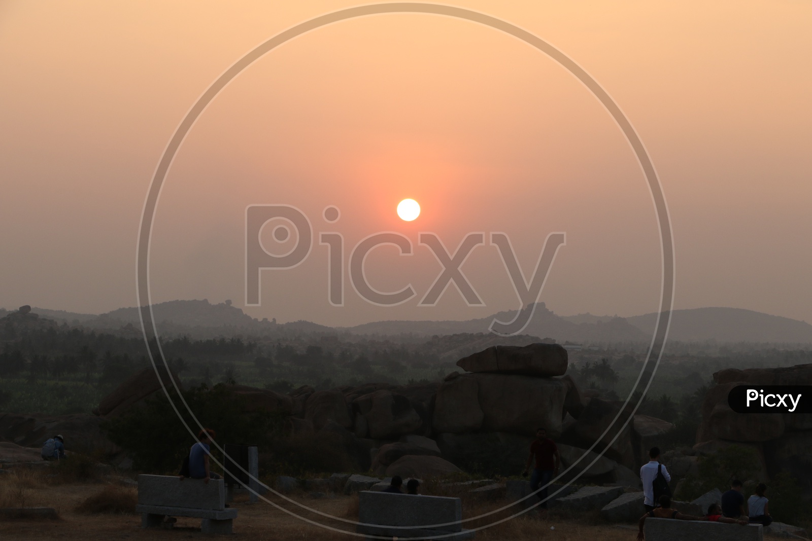 A Tourist / Visitor Enjoying the Sunset Views From Hill Top Of Hampi , Karnataka
