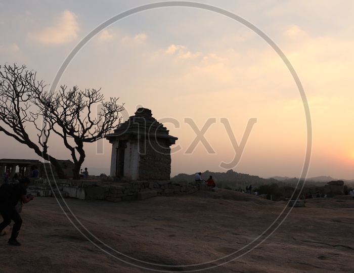 Tourists / Visitors  Enjoying the Sunset Over the Rock Hill Chain From a Hill Top in Hampi , Karnataka