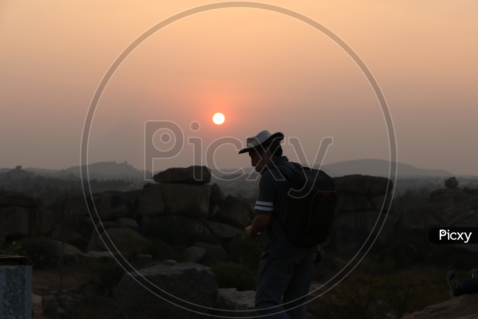 A Couple Enjoying the Sunset Over the Rock Hill Chain From a Hill Top in Hampi , Karnataka