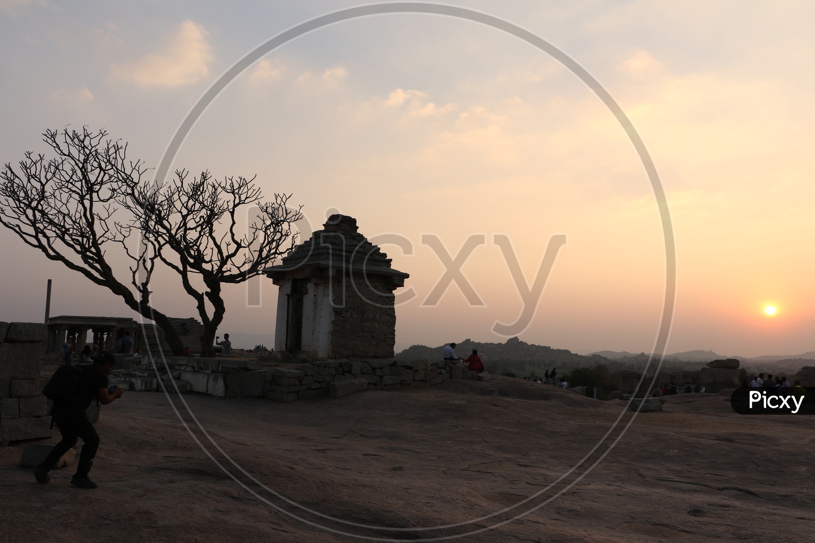 Tourists / Visitors  Enjoying the Sunset Over the Rock Hill Chain From a Hill Top in Hampi , Karnataka