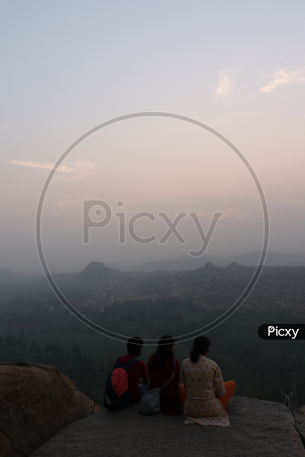 Tourists / Visitors Enjoying the Sunset Over The Rock Hills In Hampi , Karnataka