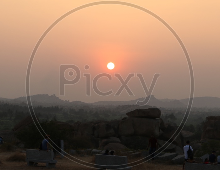 A Tourist / Visitor Enjoying the Sunset Views From Hill Top Of Hampi , Karnataka