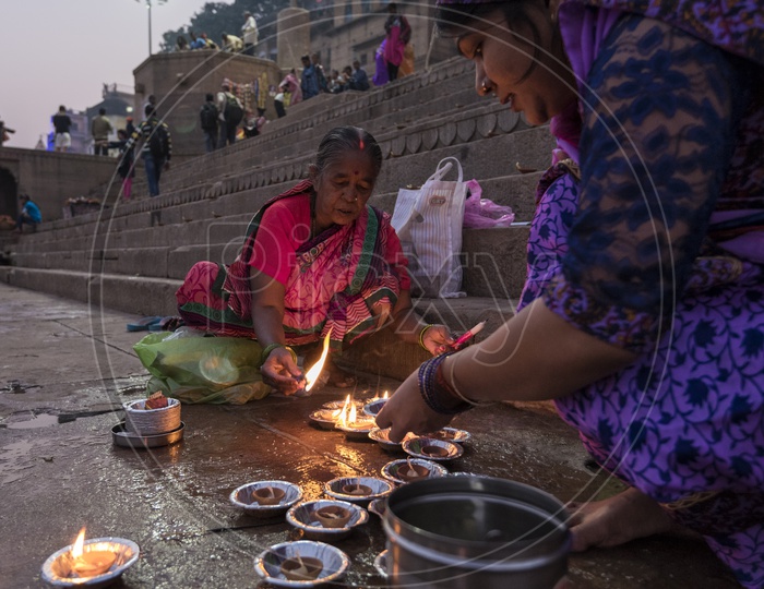 A Woman Lighting Dias in River banks of varanasi