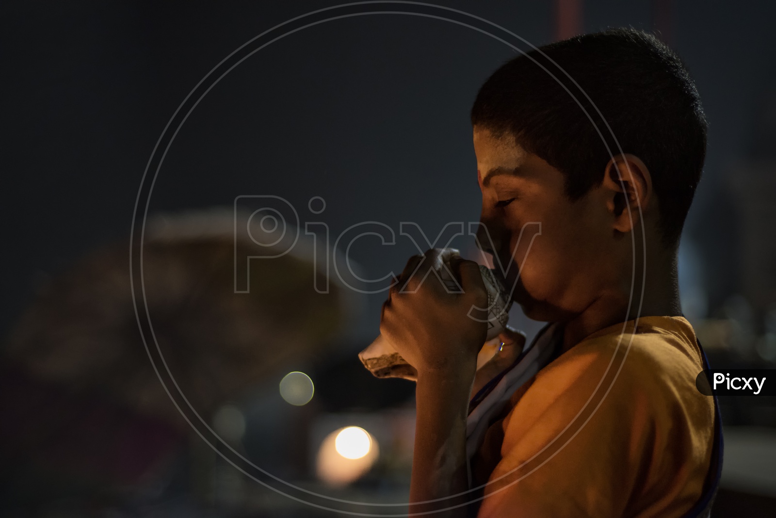 A Child Priest blowing the Conch Shell  in varanasi