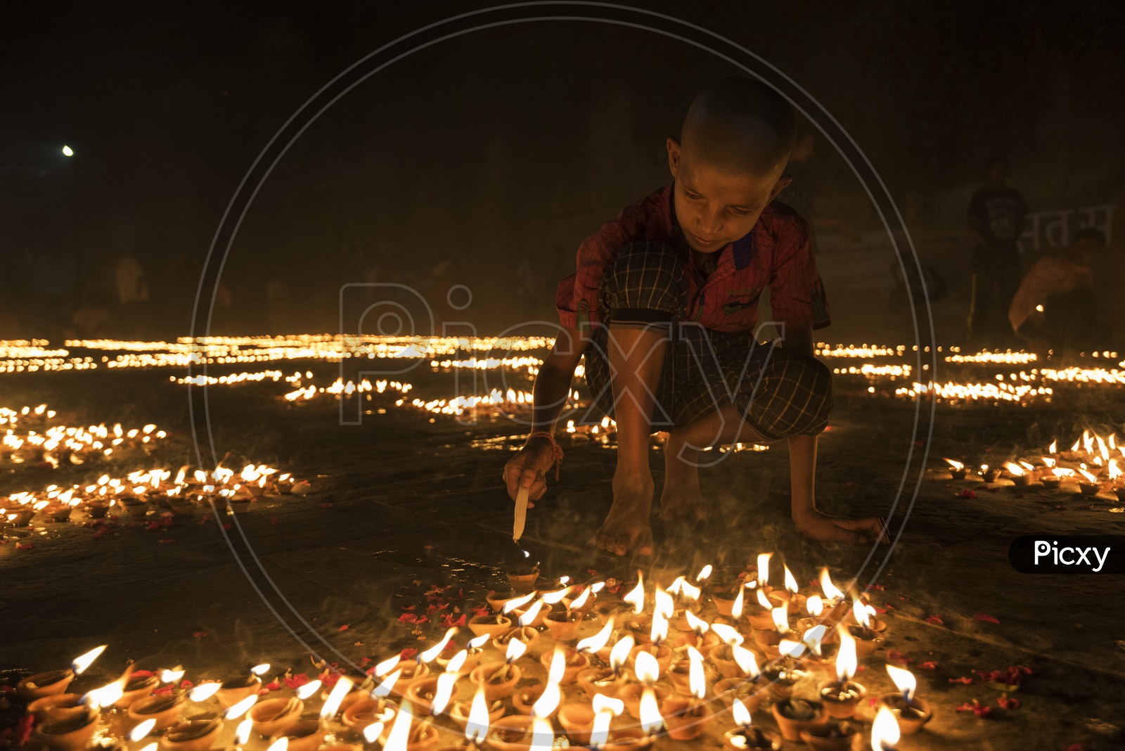 Kid lightening up Diya's in Varanasi