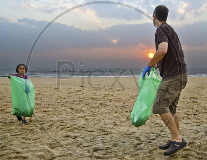 Father and daughter helping to keep the beach clean