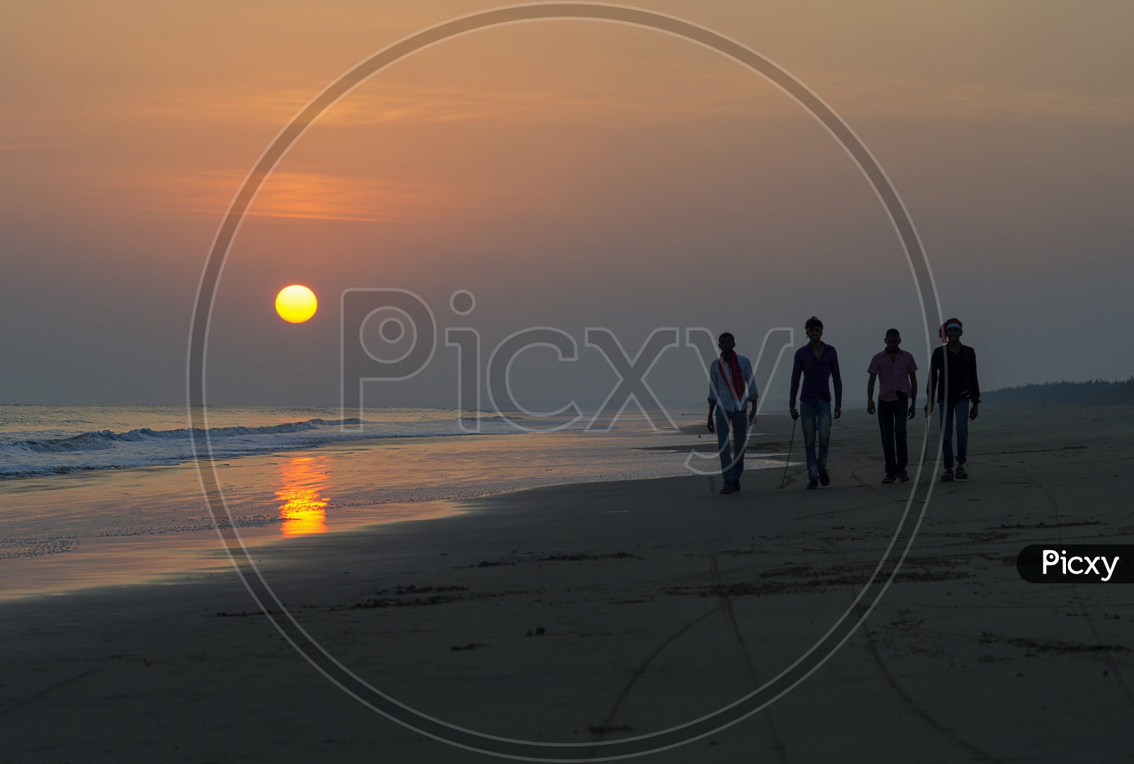 People walking in Surya Lanka Beach with beautiful sunset in the background
