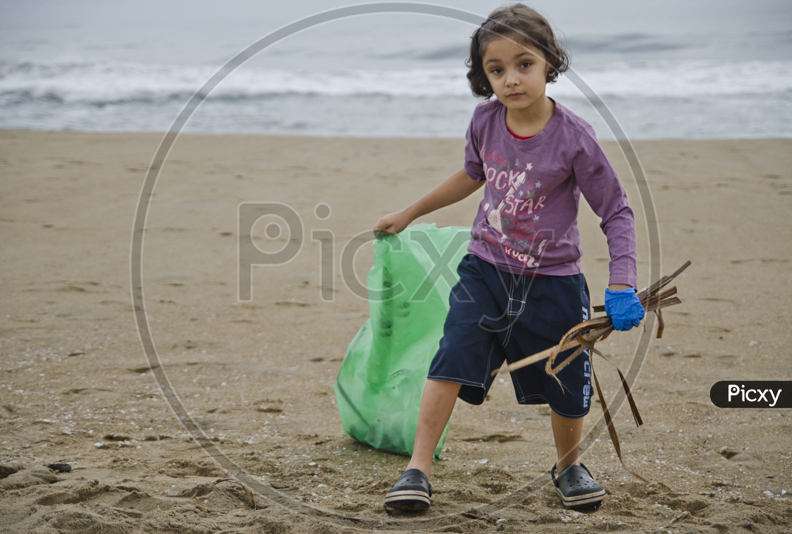 Little girl collecting the trash into a Trashbag