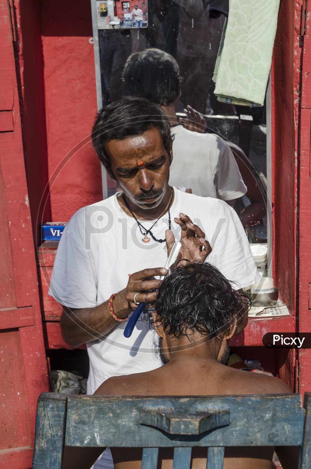 Barber shaving the hair of a man