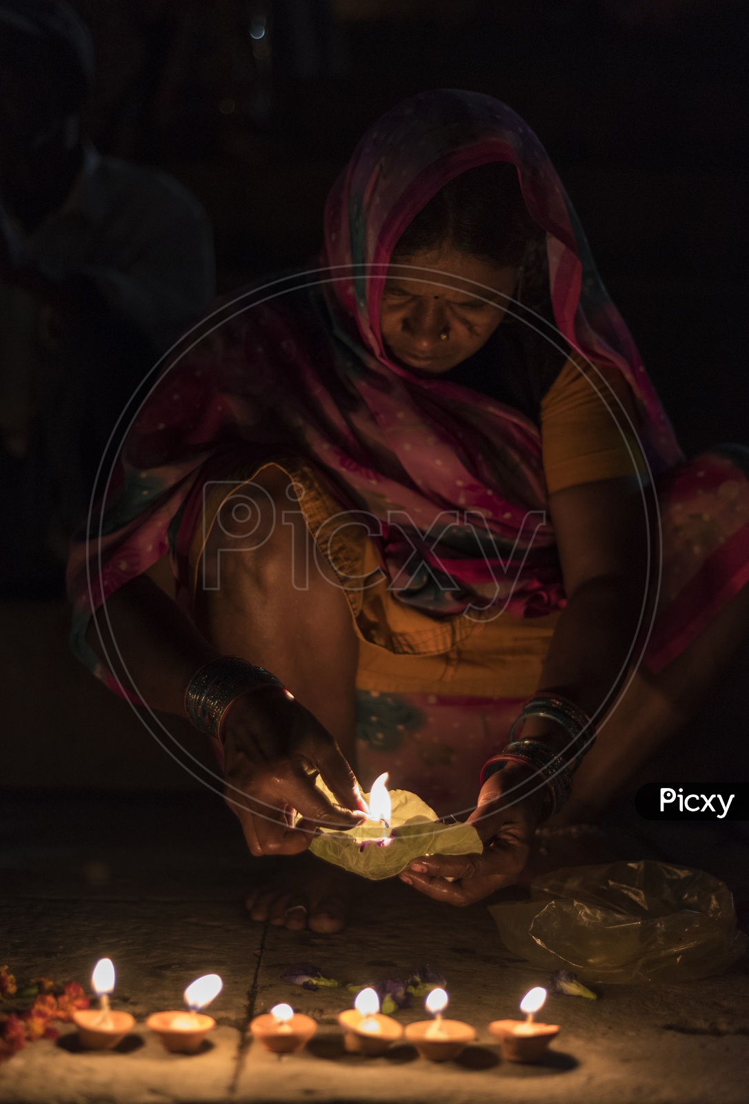 A Woman Lighting Dias in River banks of varanasi
