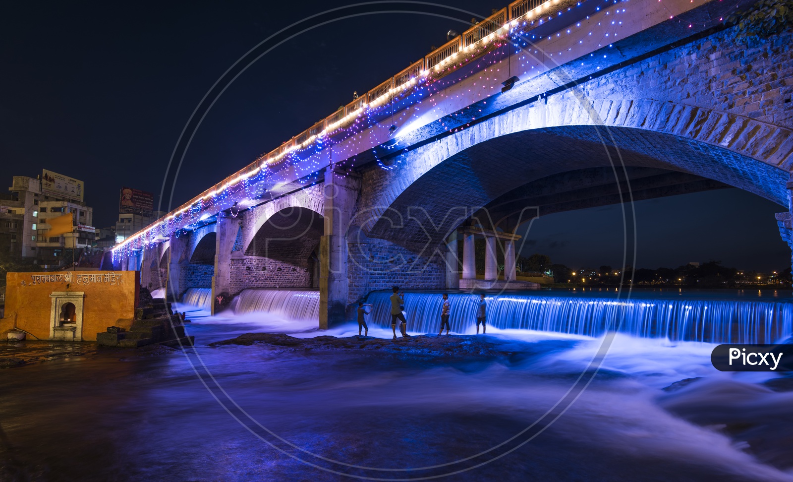 A long  exposure shot of Children Playing In a Water Channel In nasik With Bridge In Night Time