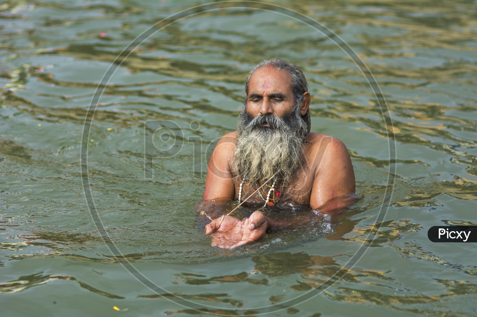 Portrait of an old man taking bath in the river