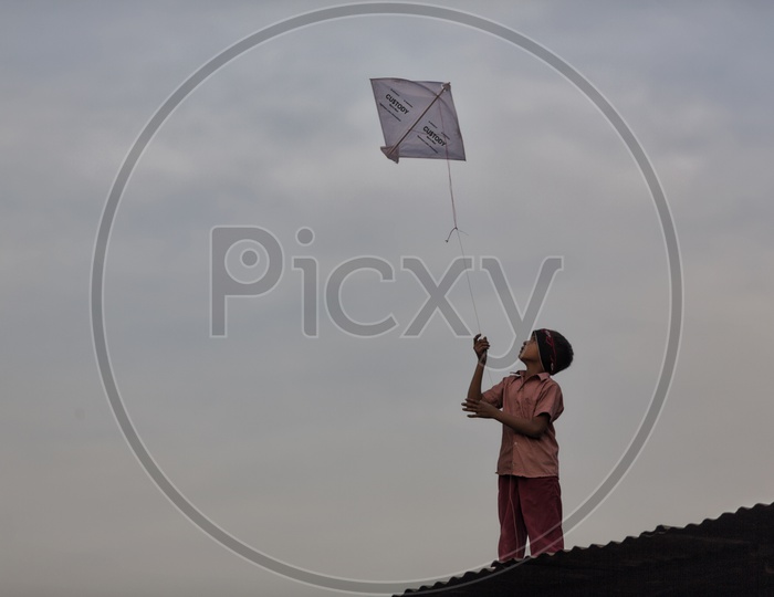 Indian Boy Flying Kites On Their House Terrace in Gujarat