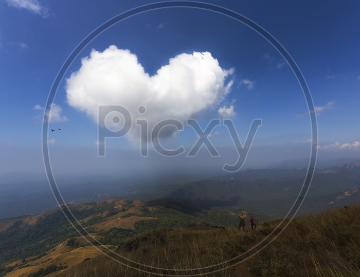 A Beautiful View of a Landscape With Clouds Forming as a Heart Shape in Sky