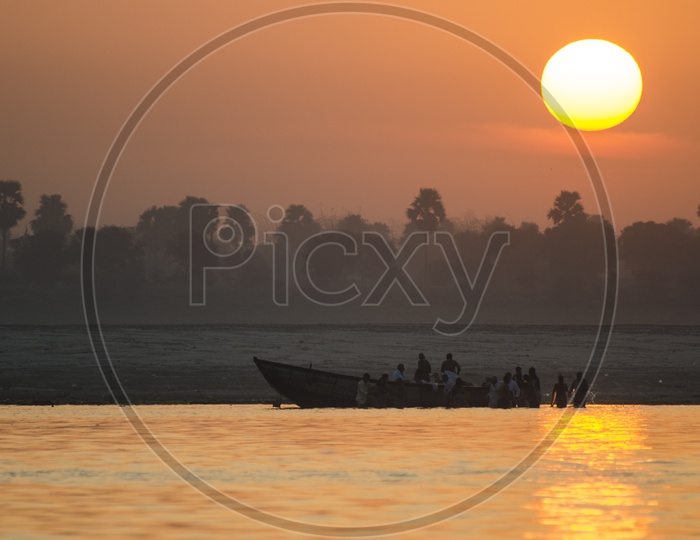 Beautiful Sunrise in Varanasi with people traveling in boat in foreground
