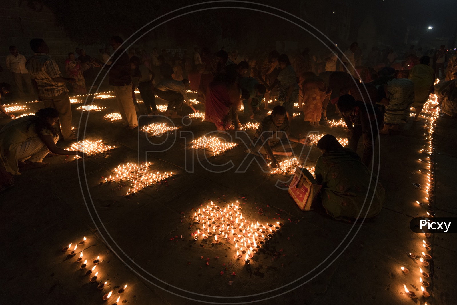 People Lightening up diya's in Varanasi