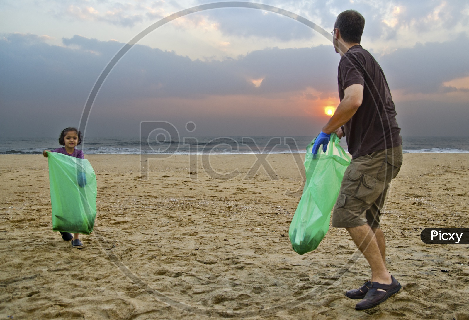 Father and daughter helping to keep the beach clean