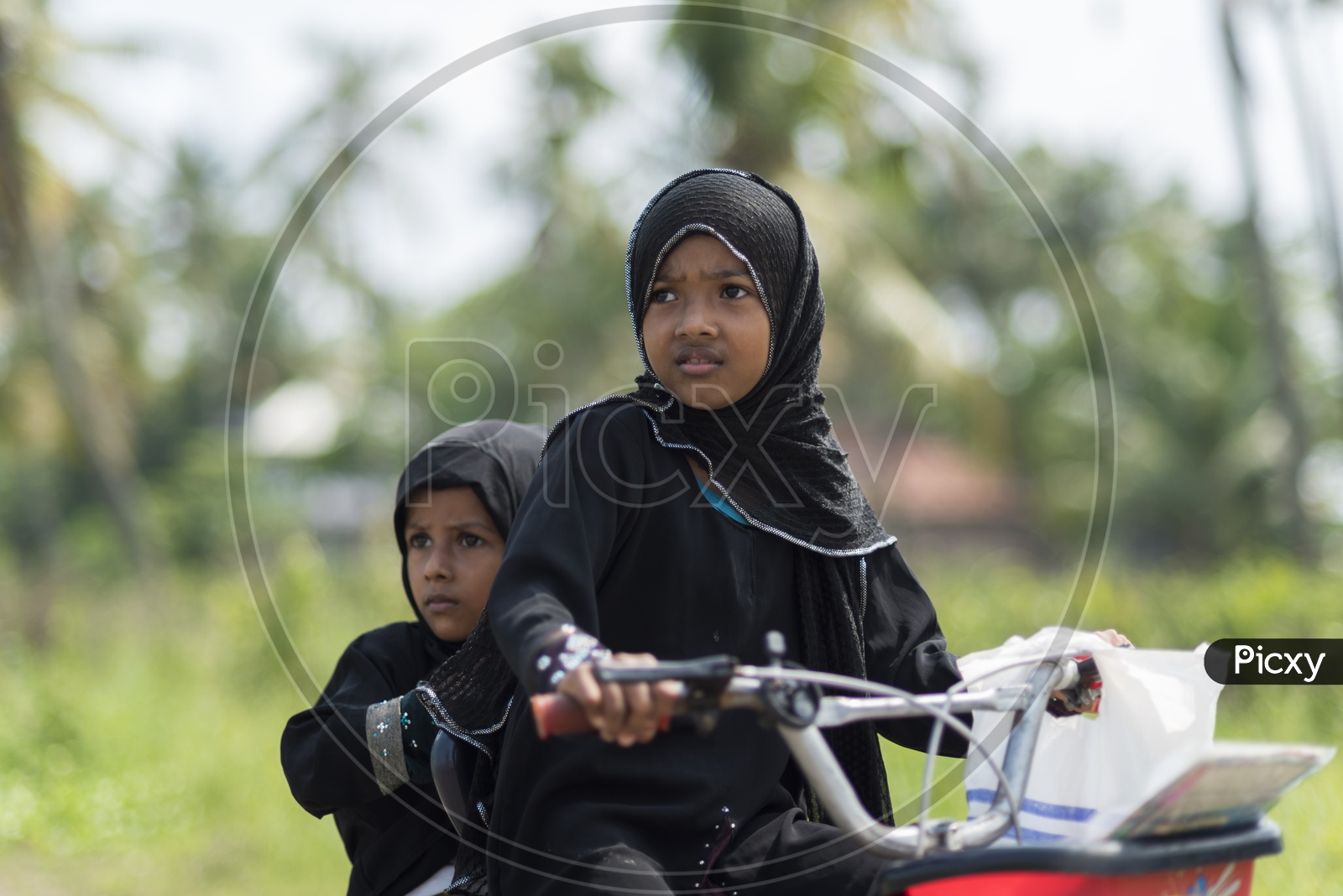 Indian Muslim Girl Child in Burkha Riding Bicycle With Her Sister on  Backside