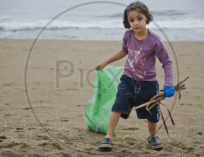 Little girl collecting the trash into a Trashbag
