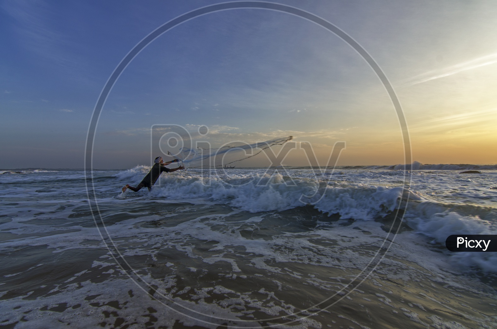 Fisherman spreading the net at dawn in the beach