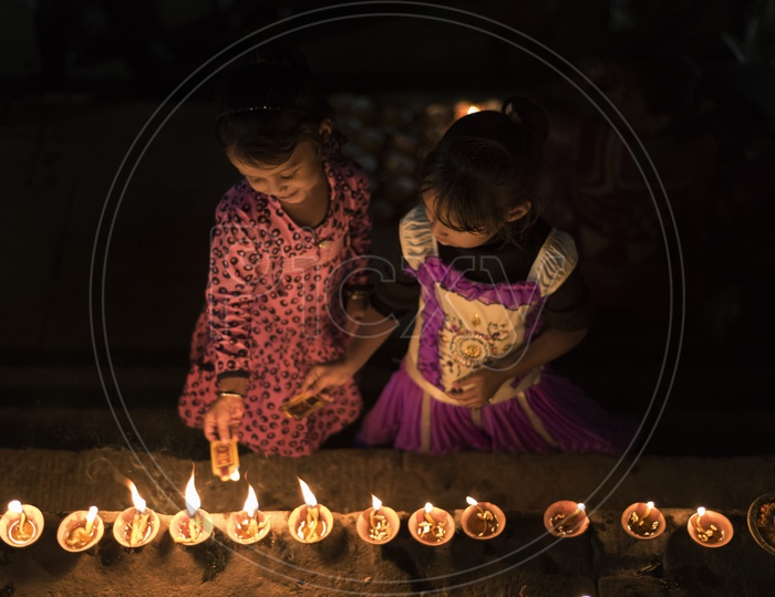 Girl Children Lighting Dias on River Banks of Varanasi