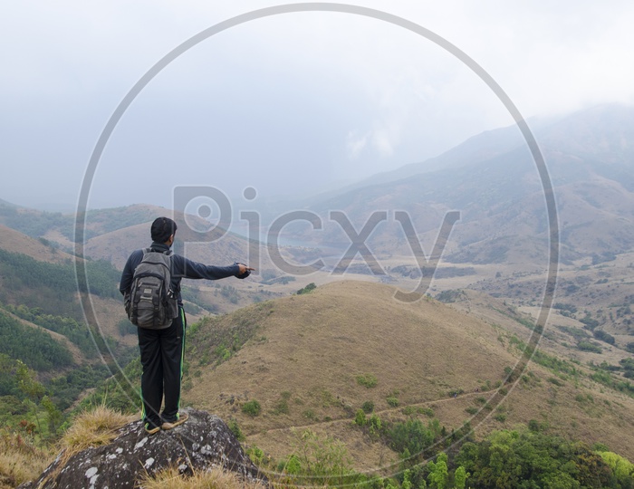 Man pointing something standing at a hillstation