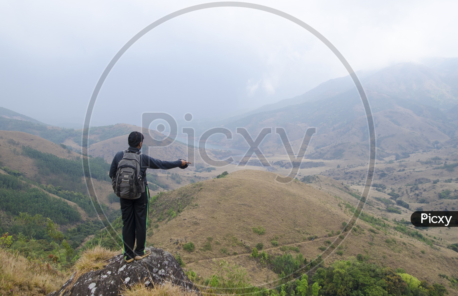 Man pointing something standing at a hillstation