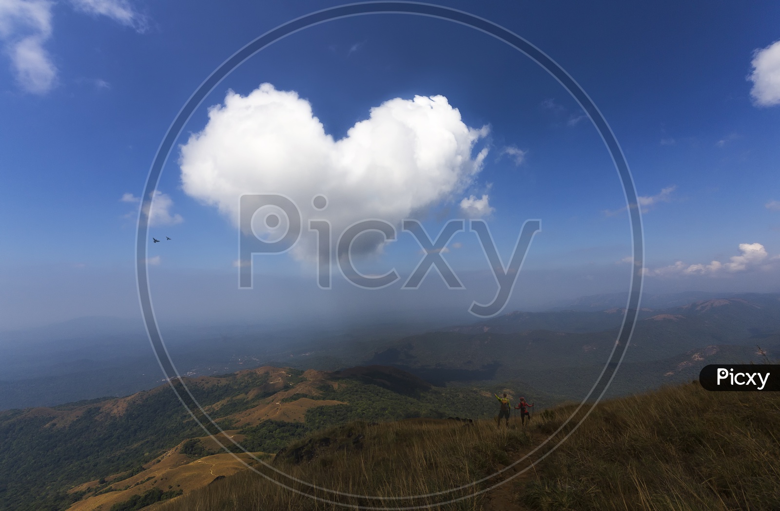 A Beautiful View of a Landscape With Clouds Forming as a Heart Shape in Sky
