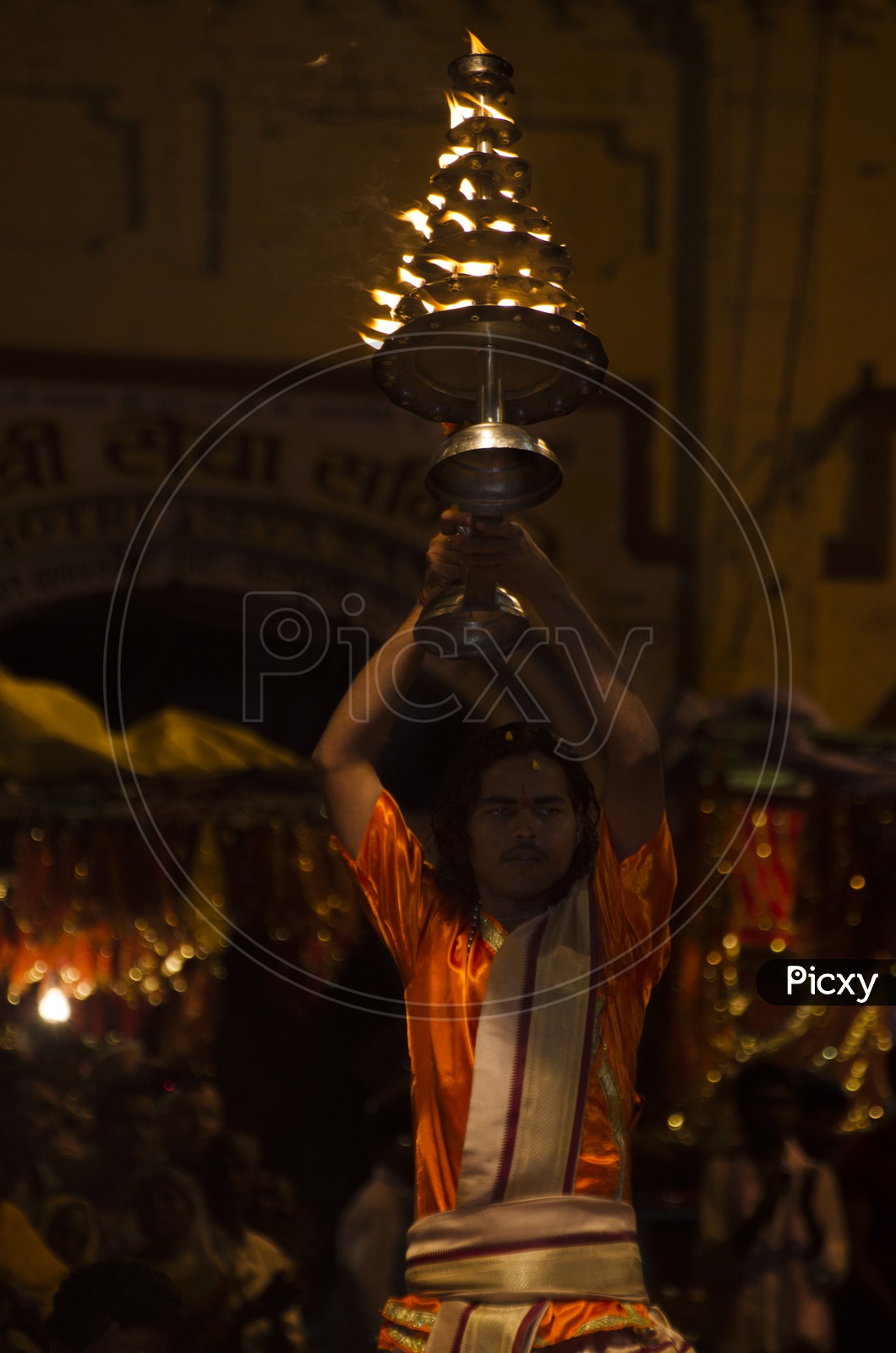 Archaka carrying the lamp ornament