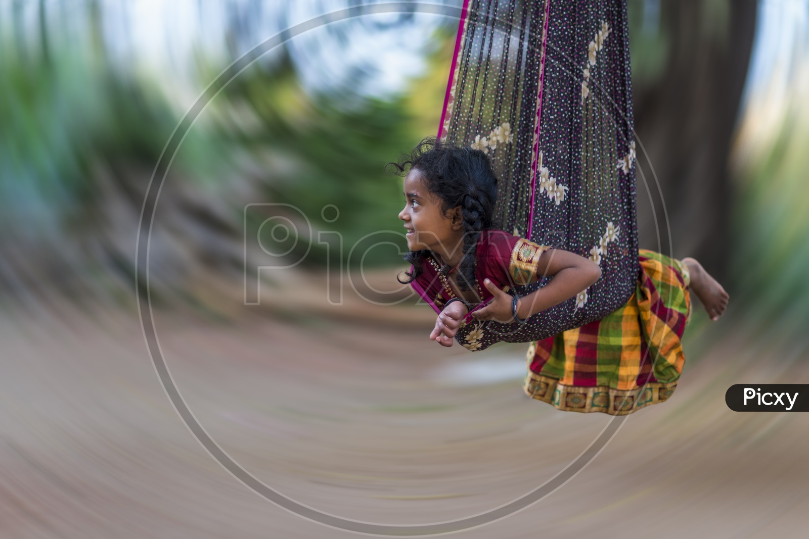 A Panning Shot Of a Girl Child In  a Swing