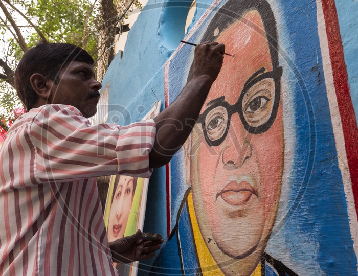 An Artist painting Ambedkar Picture On Wall