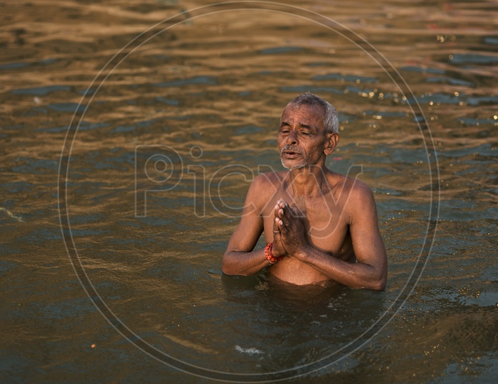 Indian Hindu Devotee Taking a Holy Bath in Ganga River In Varanasi