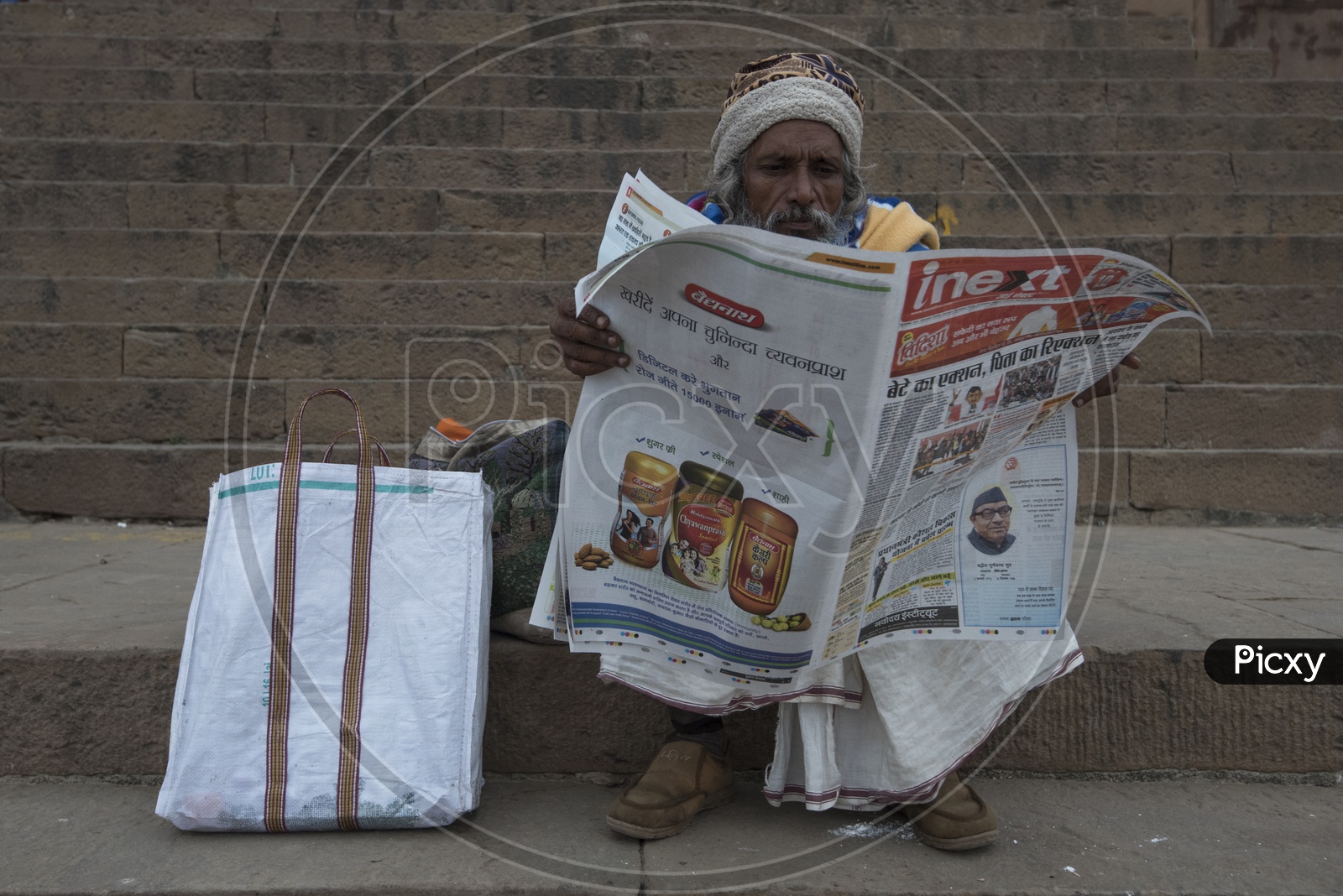Old man reading newspaper in Varanasi