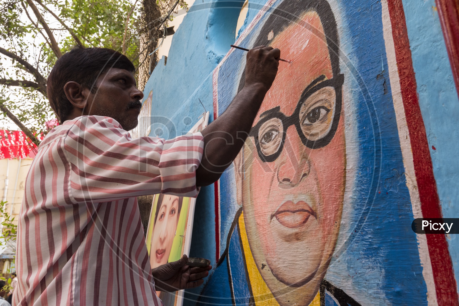 An Artist painting Ambedkar Picture On Wall