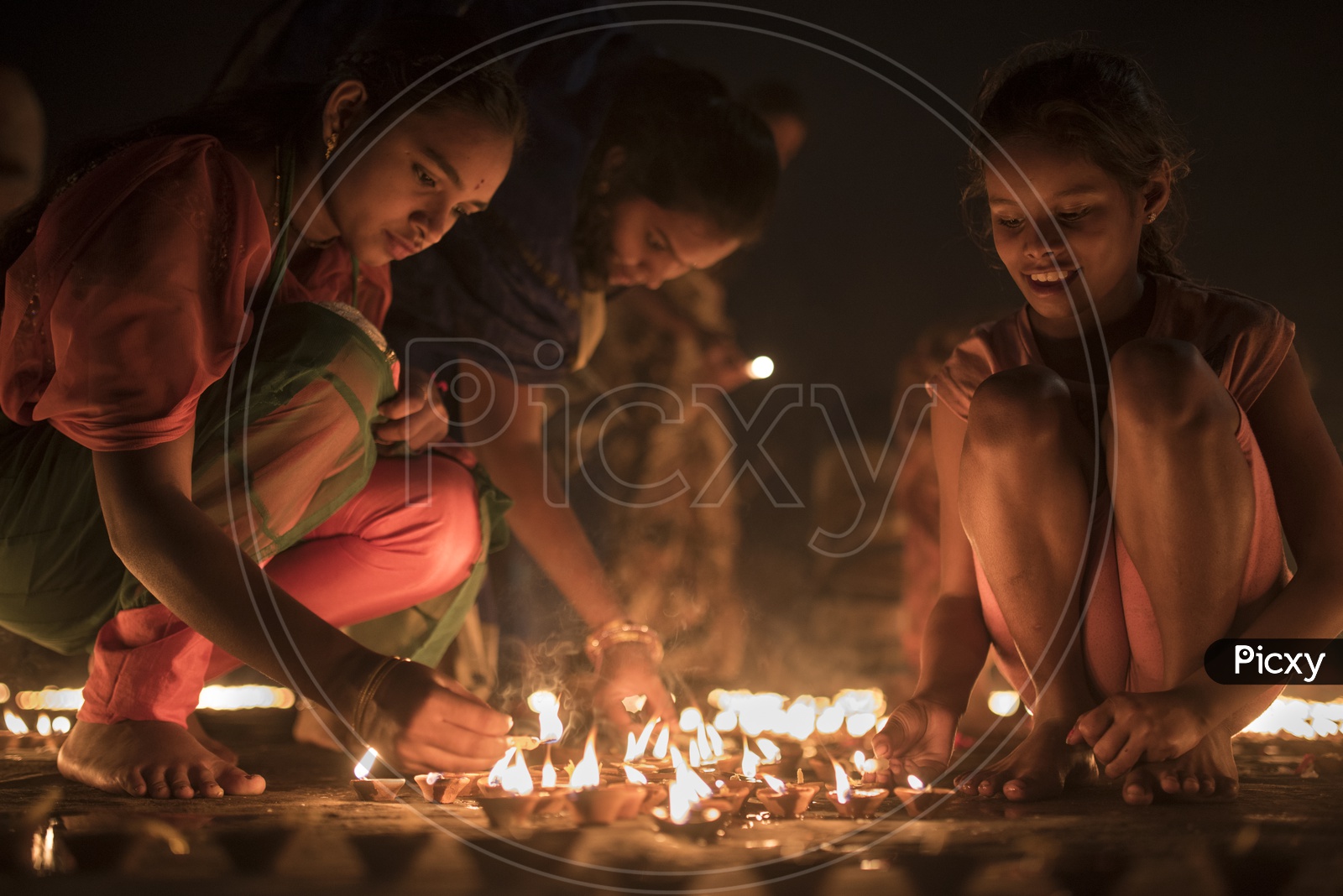 Devotees lighting dia's on the eve of Dev Diwali.