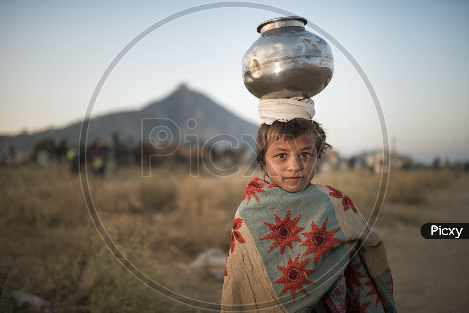 An Indian Boy With a Water vessel on Head in Pushkar Camel fair