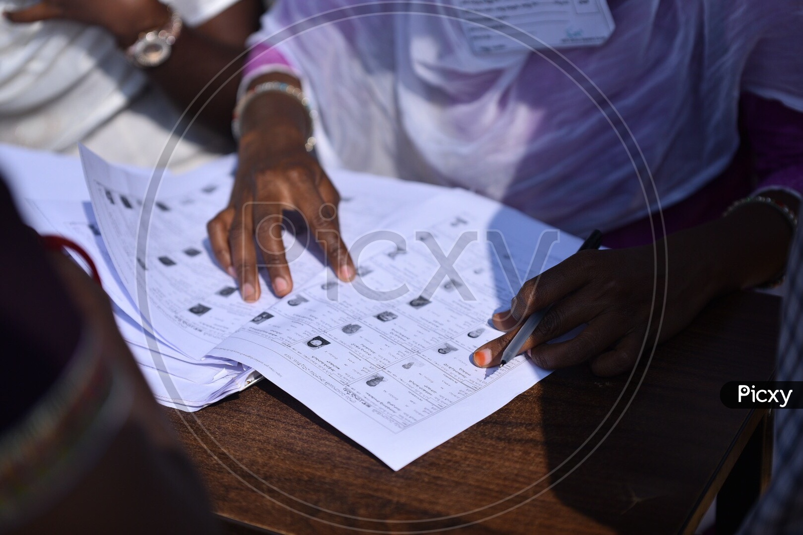 A Booth Officer Checking The Voters List At A Polling Booth In Panchayath Elections 2019