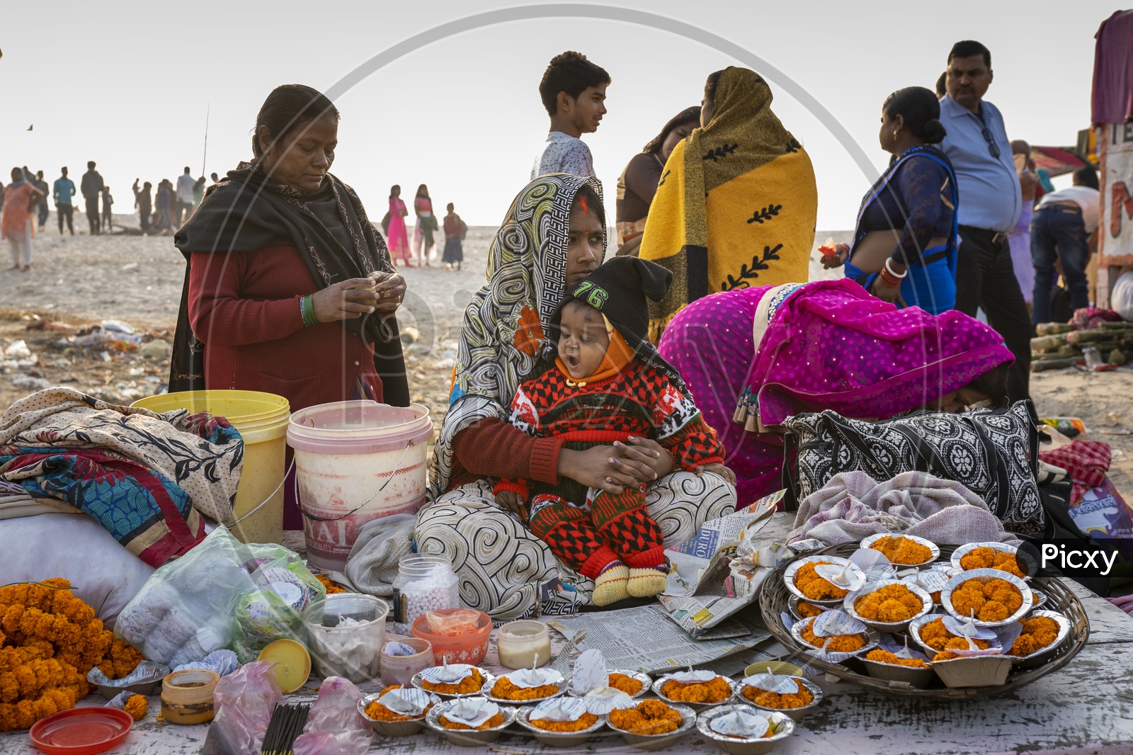 Indian Women selling diya's and flowers on the bank of River Ganga in Varanasi