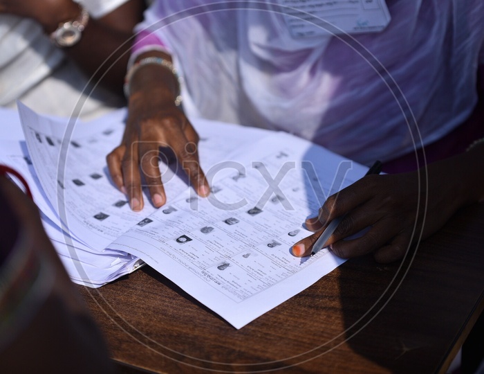 A Booth Officer Checking The Voters List At A Polling Booth In Panchayath Elections 2019
