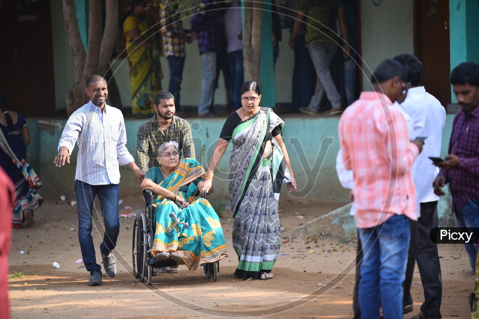 An old Woman Being Taking To Voting Booth in a Wheel Chair for Casting Her Vote In Telangana Pachayath Elections 2019