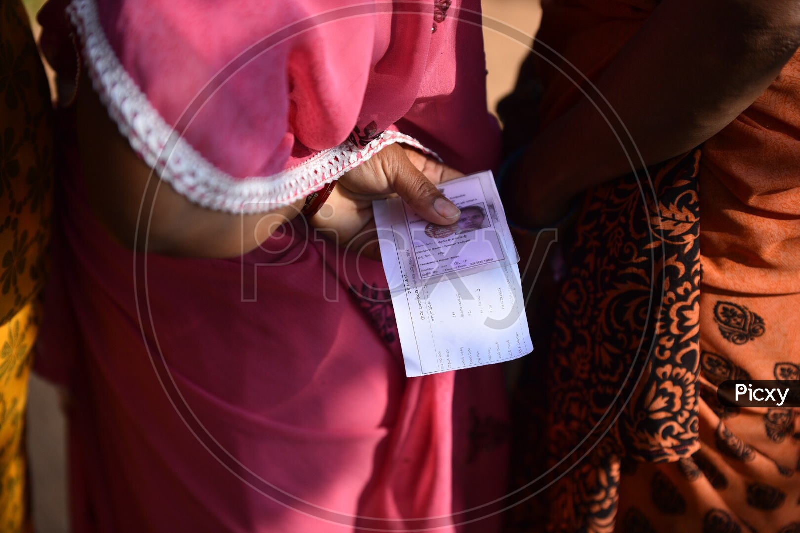 A Woman in Queue Line With Her Voter Card in Hands For Casting Vote in Telangana Panchayath Elections 2019
