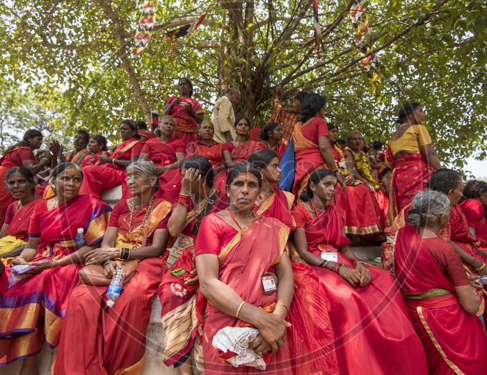 A big group of devotees resting under a banyan tree after the rituals.