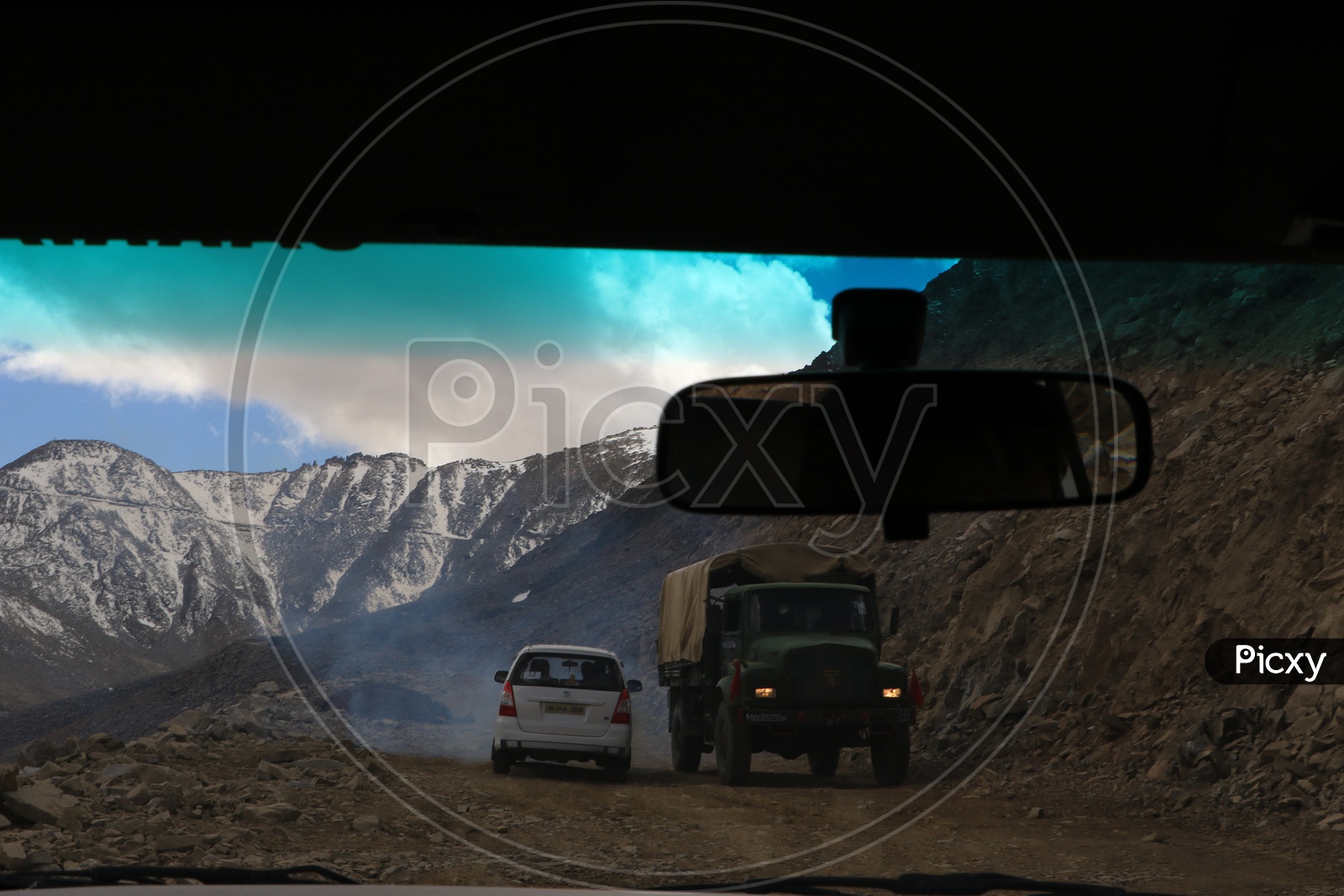 Military van moving on leh roads with beautiful snow capped mountains in the background