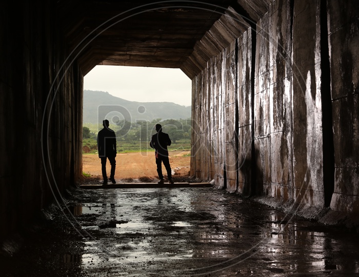 Two persons standing in a tunnel