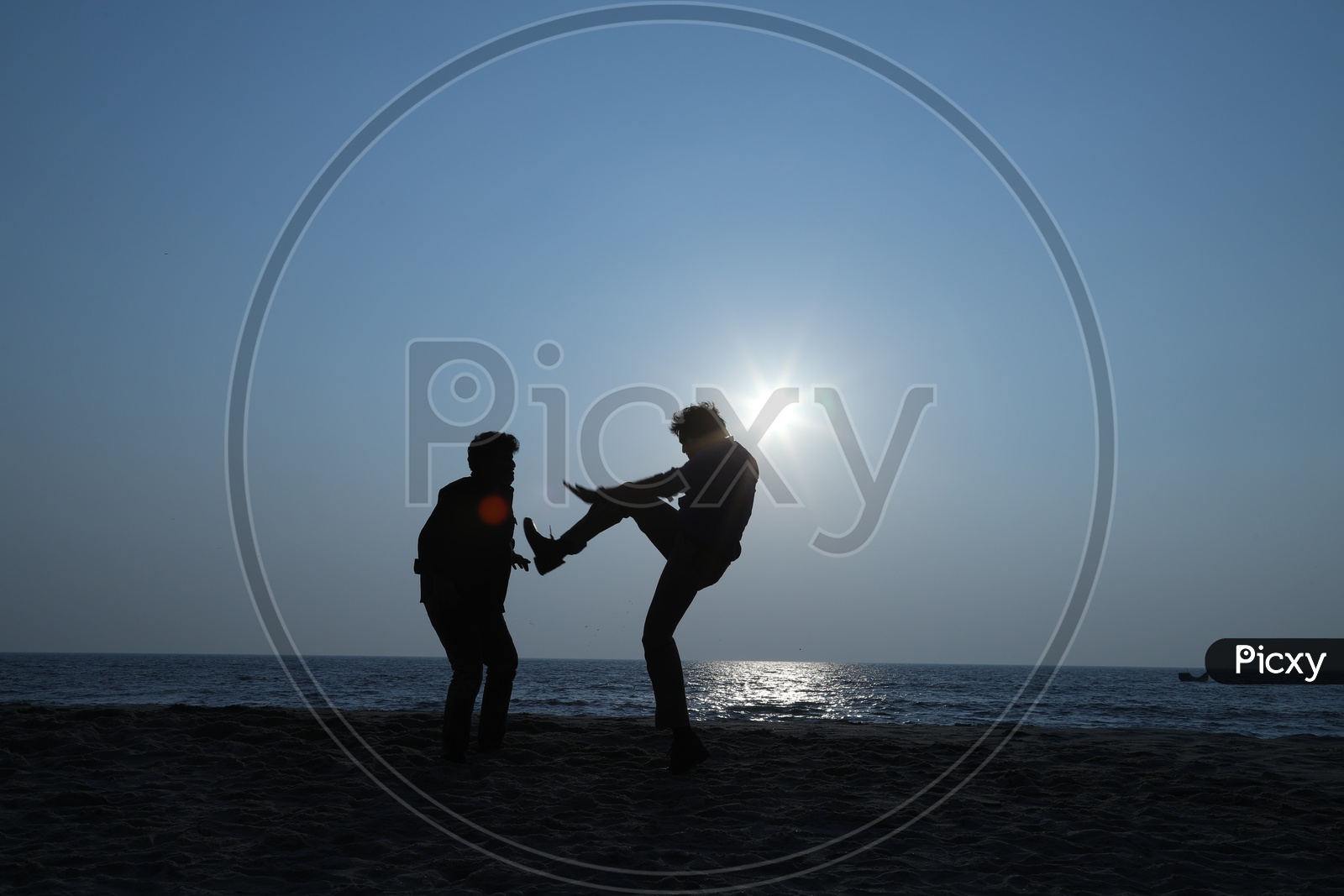 two men fighting at a beach