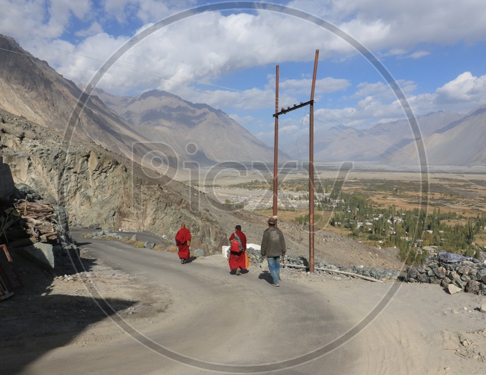 People walking in leh road with beautiful mountains in the background