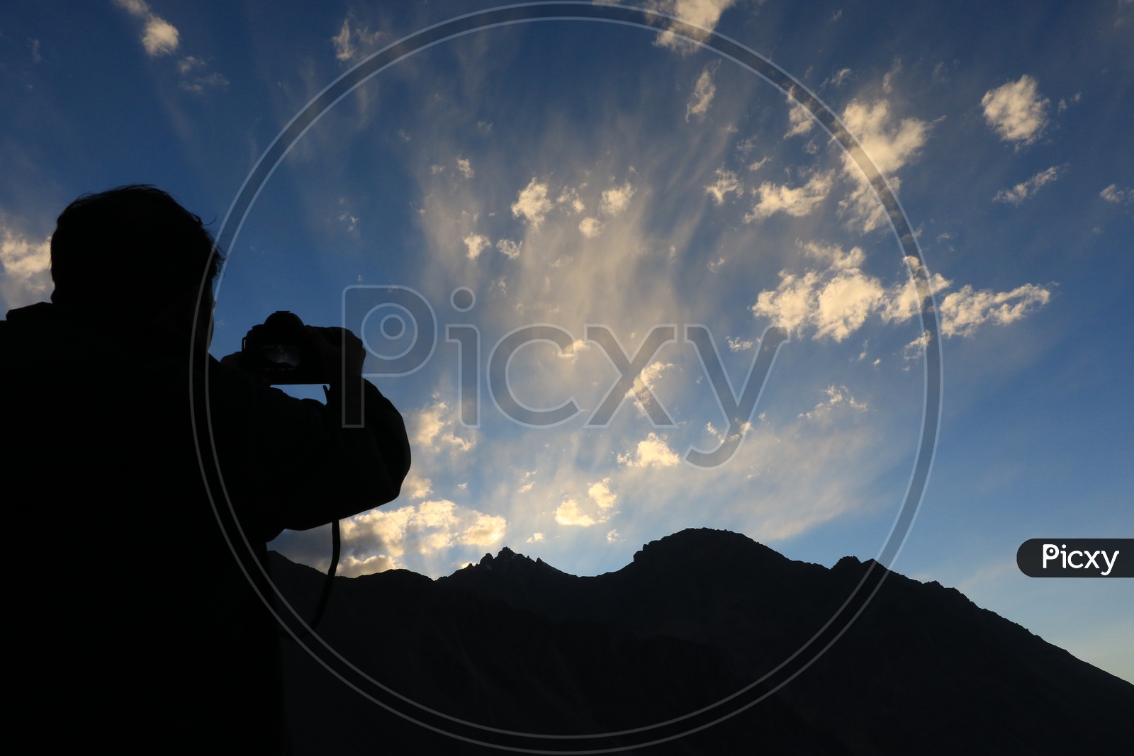 Man taking a picture of a landscape of the mountains