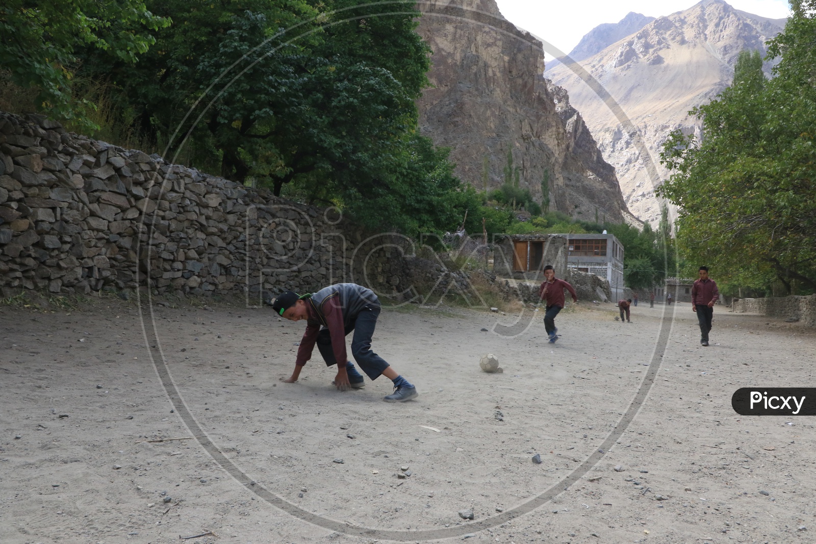 school kids playing football game in leh