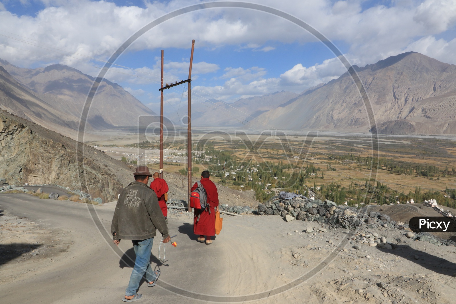 People walking in leh road with beautiful mountains in the background
